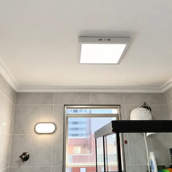 Banheiro com plafon de LED quadrado e arandela
