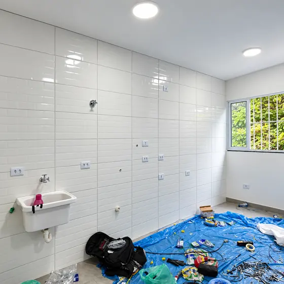 Lavanderia com novas tomadas na parede de azulejo durante a obra